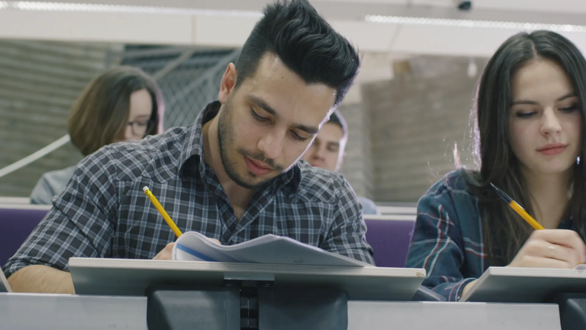 Estudiantes toman notas durante una clase.